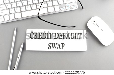 CDS Credit Default Swap text on a paper with keyboard on grey background