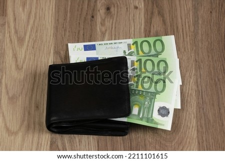 300 euros sticking out of the wallet. Three paper banknotes of 100 euros each. Symbol for growing expenses, inflation, paying household bills, salary, bonus, winnings, lottery. Royalty-Free Stock Photo #2211101615
