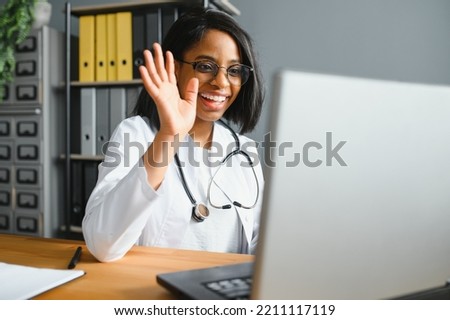 African female doctor talk with patient make telemedicine online webcam video call. Woman therapist videoconferencing on computer in remote telemedicine laptop virtual chat. Telehealth concept Royalty-Free Stock Photo #2211117119