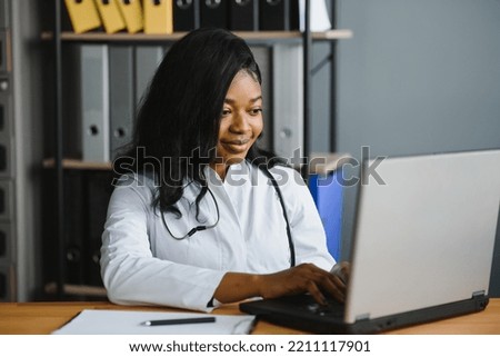 healthcare, medical and technology concept - african female doctor with laptop. Royalty-Free Stock Photo #2211117901