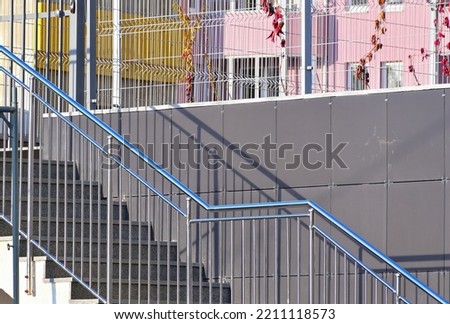 Stone staircase with metal railings on the background of a residential building