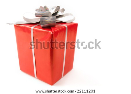 Corner of red giftbox decorated with silver shiny ribbon and knot
