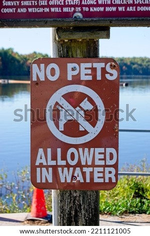 No pets allowed in water sign at lake side Royalty-Free Stock Photo #2211121005