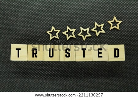 wooden cube with the word trusted and five stars. Business and Trust concept. Copy space.
