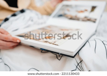 Selective focus and blurry photos. a woman holds a photo book from a family photo shoot. professional photographer and printing house.