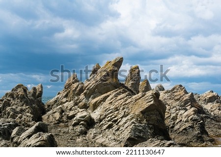 sharp jagged basalt rocks on the sea coast, Cape Stolbchaty on Kunashir Island Royalty-Free Stock Photo #2211130647