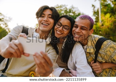 Three multiracial friends taking selfie photo during spending time together in skate park