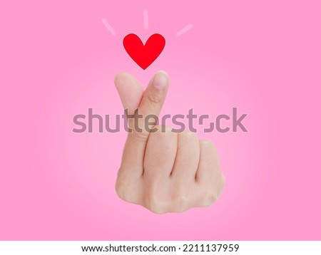 Make a hand sign of Mini Heart symbol of love on pink background.