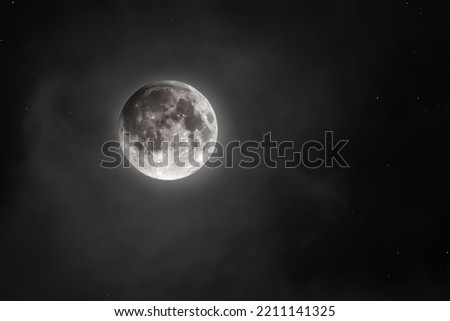 A picture of the moon among the clouds and stars