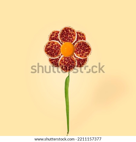 
Flower with pepperoni pizza and yolks. Modern food concept. Place for text. Graphics on a nice beige background