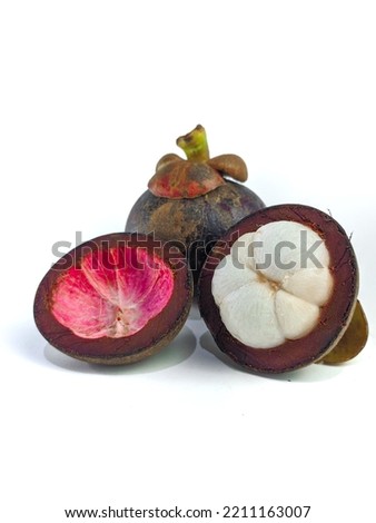 Mangosteen and cross section showing the thick purple skin and white flesh of the queen of friuts, on white background