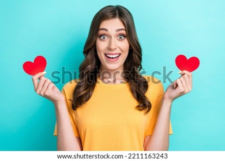 Closeup photo of young pretty gorgeous nice shocked lady hold red paper heart toothy smile unexpected feelings isolated on aquamarine color background