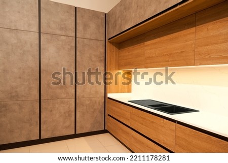 Modern brown wood oak kitchen cabinet equipment and stylish granite black sink in a home Royalty-Free Stock Photo #2211178281