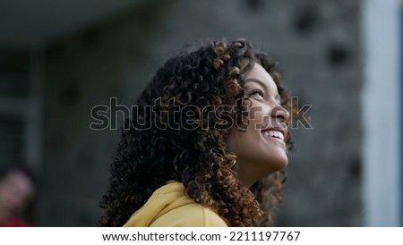 One young woman feeling gratitude closeup face. Portrait of a hopeful African American girl looking at sky with FAITH