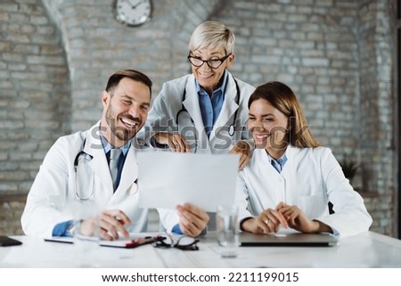 Happy doctors talking about medical documents on a meeting in the office