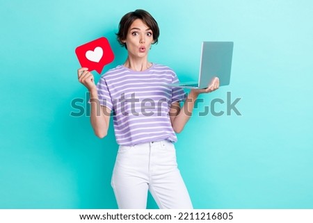 Photo of attractive astonished lady hold red card netbook impressed low price device shop sale discount isolated on cyan color background