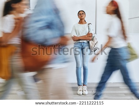 Anxiety, fear and a woman in busy crowded university sad and thinking. Stress, doubt and depression, student in hallway before interview, exam or class. Motion blur, people and girl waiting in lobby.