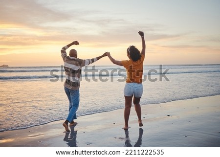 Love, travel and happy couple at beach enjoying summer vacation or fun honeymoon at sunset while holding hands and being playful. Laughing, energy and seaside holiday with black man and woman at sea Royalty-Free Stock Photo #2211222535