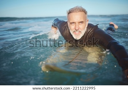 Water, beach and man surfing waves for adventure during retirement on holiday in ocean in summer. Mature surfer on board in the sea on vacation on an island during travel in Hawaii in nature Royalty-Free Stock Photo #2211222995