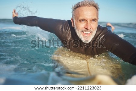 Beach, water and old man surfer swimming on a summer holiday vacation in retirement with freedom in Bali. Smile, ocean and senior surfing or body boarding enjoying a healthy exercise on sea of Island Royalty-Free Stock Photo #2211223023