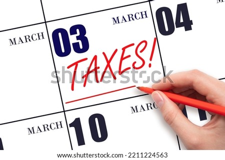 3rd day of March. Hand drawing red line and writing the text Taxes on calendar date March 3. Remind date of tax payment. Tax day concept. Spring month, day of the year concept.