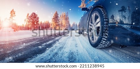 Closeup view of the car's wheel on the snowy road in natural park Royalty-Free Stock Photo #2211238945