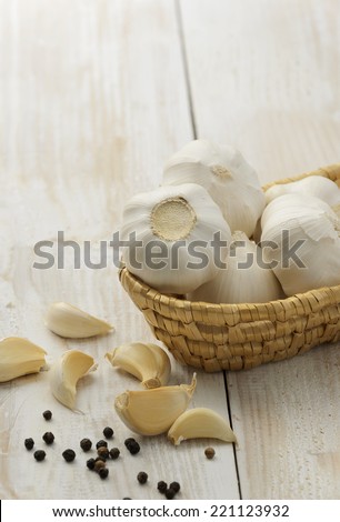 Cloves of garlic in basket on wooden background