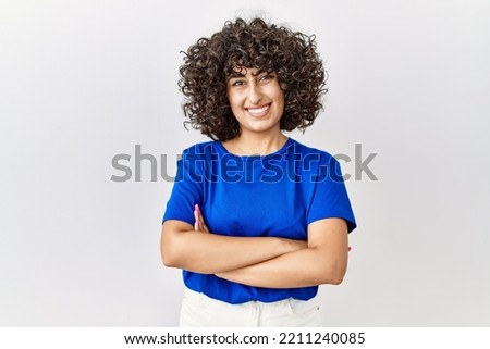 Young middle eastern woman standing over isolated background happy face smiling with crossed arms looking at the camera. positive person.  Royalty-Free Stock Photo #2211240085
