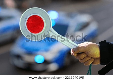 Traffic police policeman while directing traffic with a lollipop to stop vehicles. Royalty-Free Stock Photo #2211240195