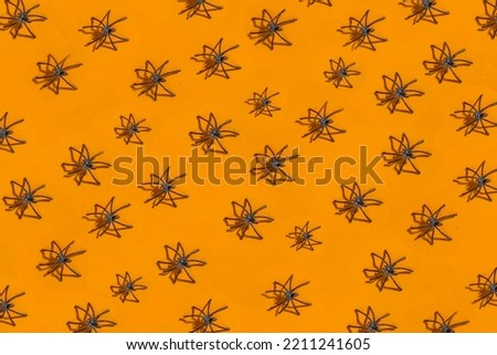 Halloween pattern background with decor black spiders on orange backdrop for design or text, template, layout.