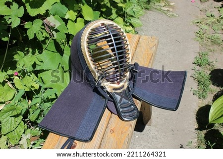A kendo helmet lying on a wooden bench Royalty-Free Stock Photo #2211264321