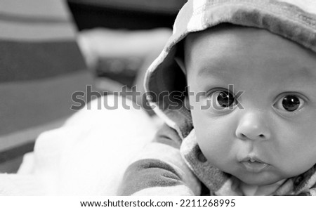 baby looking with big eyes just after having a good sleep in bed with people stock photo  
