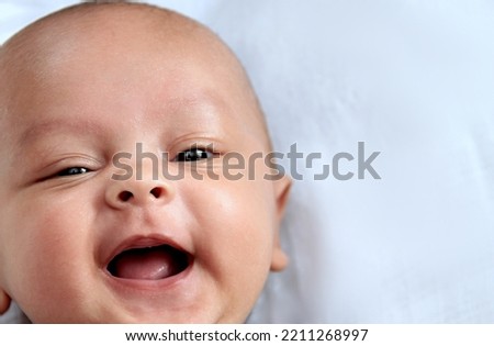 baby looking with big eyes just after having a good sleep in bed with people stock photo 