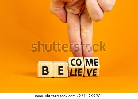 Become or believe symbol. Businessman turns wooden cubes and changes the concept word Believe to Become. Beautiful orange table orange background. Business become or believe concept. Copy space.