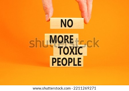 No more toxic people symbol. Concept words No more toxic people on wooden blocks on a beautiful orange table orange background. Psychologist hand. Business, psychological no more toxic people concept. Royalty-Free Stock Photo #2211269271