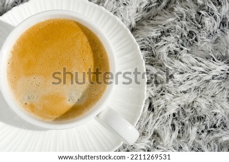 Cup of coffee on a white winter background. Delicious brewed espresso in a white porcelain mug.