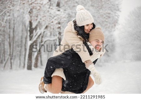 Portrait of romantic couple spending time together in forest at winter day