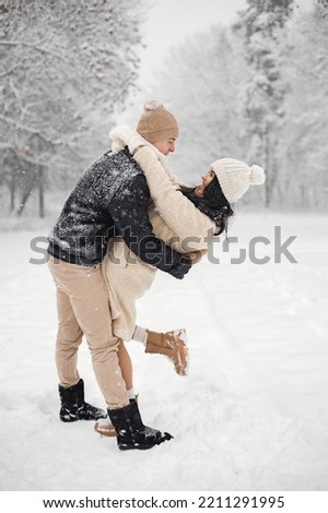 Portrait of romantic couple walking in forest at winter day