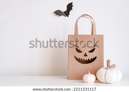 Happy Halloween sale concept background. Halloween pumpkins, paper bats and a shopping bag. Jack pumpkin lantern white wall