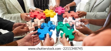 Banner background with diverse multiracial team of adult men and women who work together joining in circle colorful pieces of jigsaw puzzle. Business, education, teamwork, innovative ideas concept