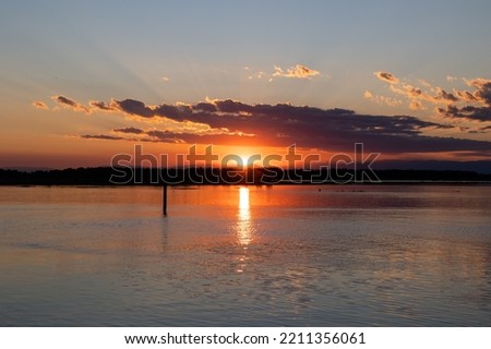 beautiful orange sunset in the cloudy sky at summer on a sea landscape