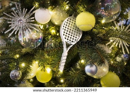 Decorated Christmas tree on blurred, sparkling and fairy background. a tennis racket in the form of a toy for decorating a Christmas tree for the new year.