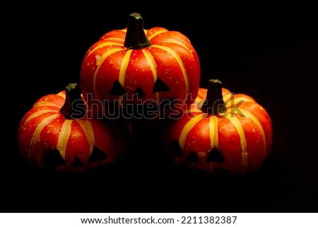 Halloween decorations concept, Scary smiling pumpkin stacked on black background.