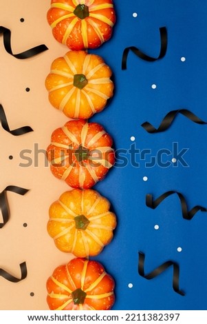 Halloween symbol concept, Scary smile pumpkins with dot are arranged on blue and cream background.