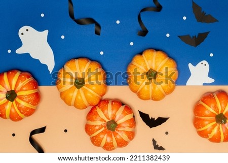 Halloween concept, Scary smile pumpkins with ghost and black bat on blue and cream background.