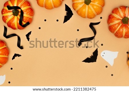Halloween decorations concept, Scary smile pumpkins and ghost with black bat on cream background.