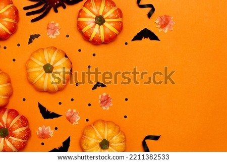 Halloween symbol concept, Scary smiling pumpkins and black bat with spider on orange background.