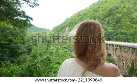 A young woman looking at Pho Khun Pha Muang Bridge or huai tong bridge                        
