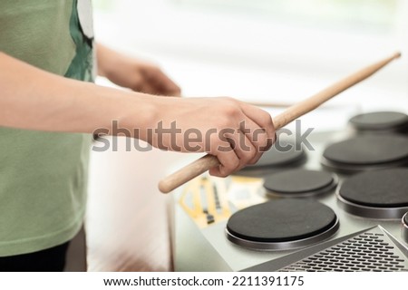 Hands of a young musician playing electronic drums with sticks, close-up, selective focus Royalty-Free Stock Photo #2211391175