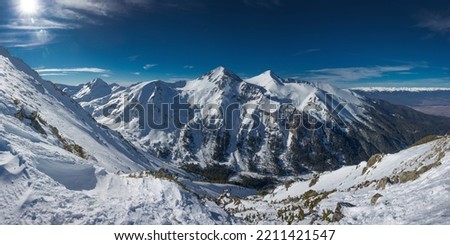 Panoramic landscape of Vihren and Kutelo peaks in sunny winter day. Observation deck at Todorka peak in the Pirin Mountains near Bansko, Bulgaria. Royalty-Free Stock Photo #2211421547